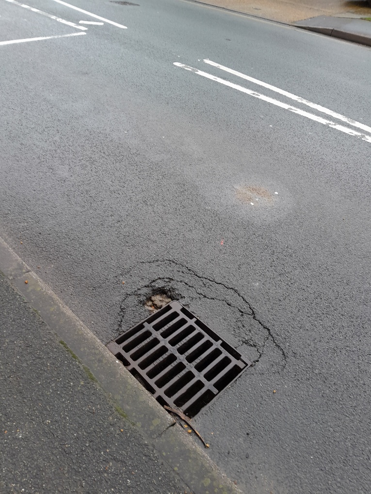 Broken carriageway by gully in Forest Road